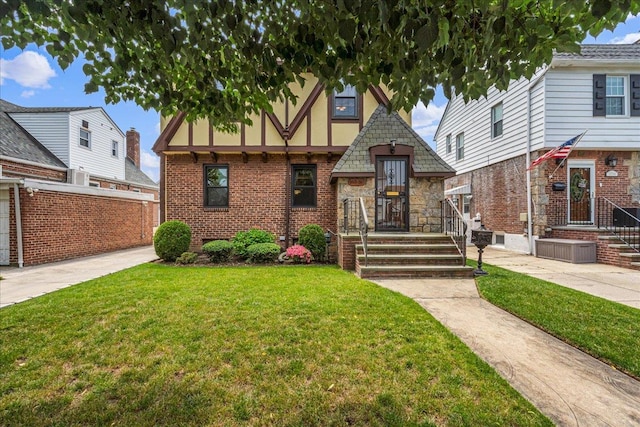 163-50 25th Dr, Flushing, NY 11358 - tudor house featuring a front lawn and stucco siding