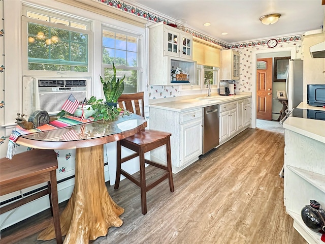 222 Beechwood Ave, Poughkeepsie, NY 12601 - kitchen featuring appliances with stainless steel finishes, light wood-type flooring, light countertops, glass insert cabinets, and ornamental molding