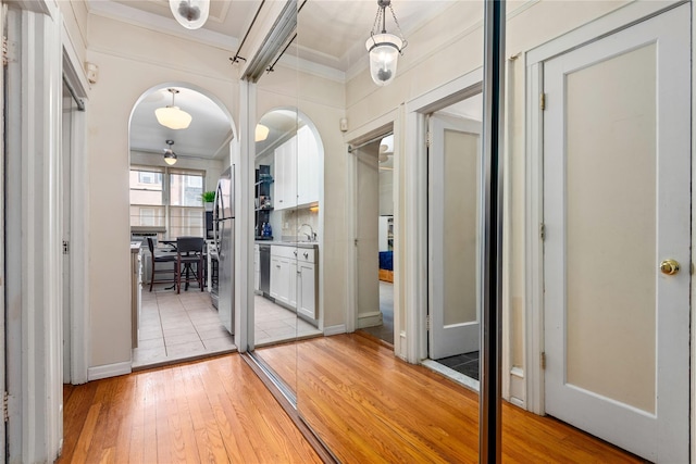4204 64th St, Woodside, NY 11377 - hall with ornamental molding, light wood-style floors, and arched walkways