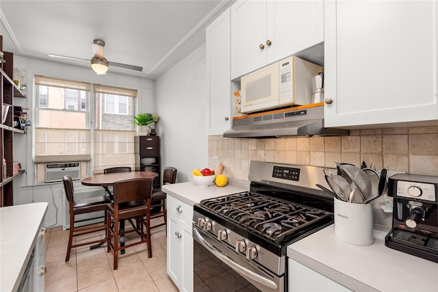 4204 64th St, Woodside, NY 11377 - kitchen featuring stainless steel range with gas stovetop, under cabinet range hood, light countertops, and white cabinetry