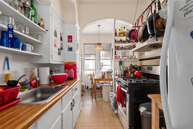 4204 64th St, Woodside, NY 11377 - kitchen featuring stainless steel gas range oven, freestanding refrigerator, open shelves, white cabinetry, and light floors