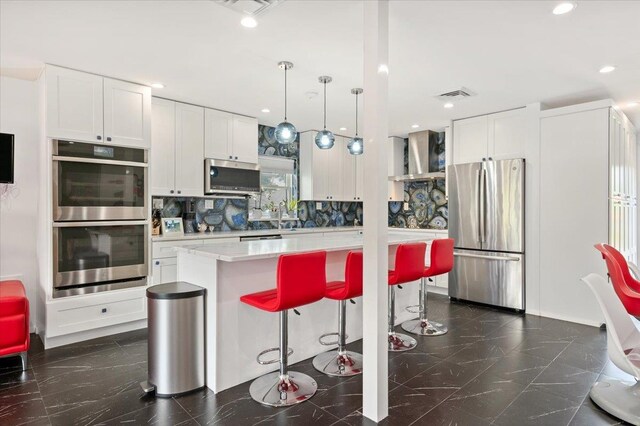 740 Eagle Dr, North Woodmere, NY 11581 - kitchen featuring stainless steel appliances, wall chimney range hood, decorative backsplash, white cabinets, and recessed lighting