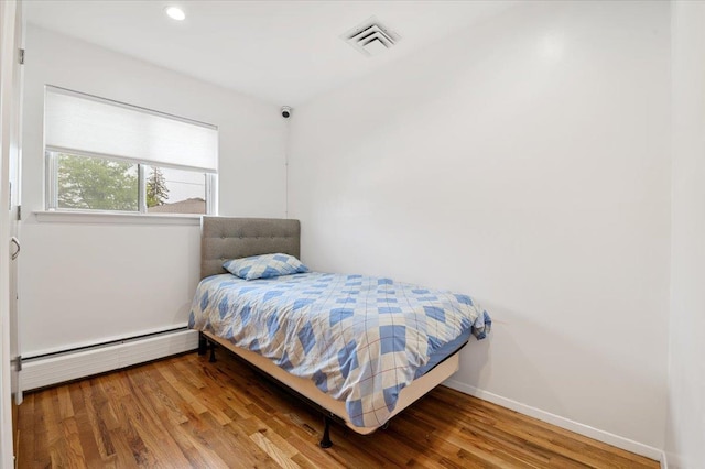 740 Eagle Dr, North Woodmere, NY 11581 - bedroom with a baseboard radiator, wood finished floors, and recessed lighting
