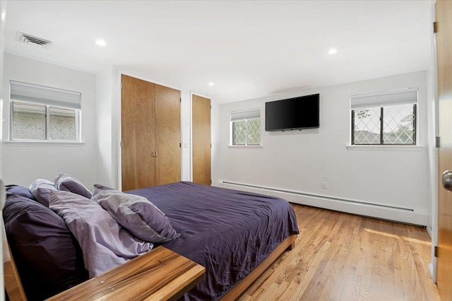 740 Eagle Dr, North Woodmere, NY 11581 - bedroom with a baseboard heating unit, light wood-style floors, and recessed lighting