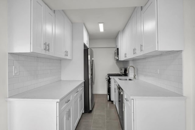 21-15 34th Ave Unit 8B, Astoria, NY 11106 - kitchen featuring appliances with stainless steel finishes, light countertops, backsplash, and white cabinetry