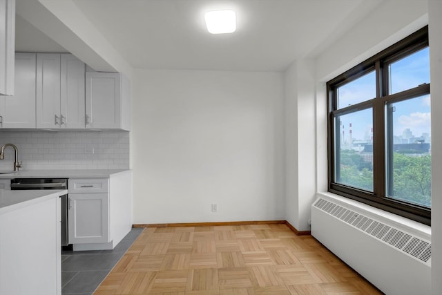 21-15 34th Ave Unit 8B, Astoria, NY 11106 - kitchen featuring radiator, plenty of natural light, light countertops, and decorative backsplash