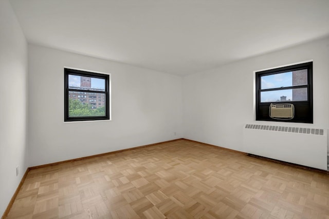 21-15 34th Ave Unit 8B, Astoria, NY 11106 - spare room featuring radiator, plenty of natural light, and cooling unit