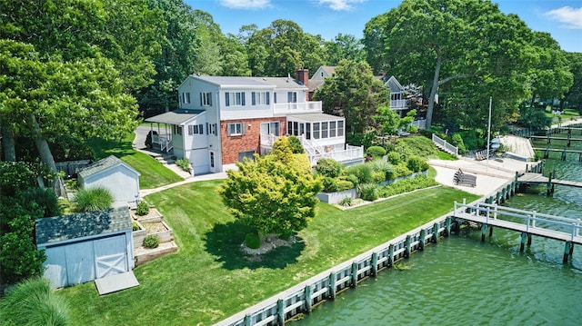 2005 Westview Dr, Mattituck, NY 11952 - rear view of house with a water view, a chimney, a lawn, brick siding, and a shed