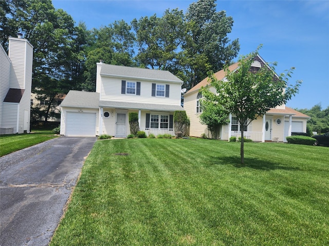 12 Grouse Path, Coram, NY 11727 - traditional-style house featuring asphalt driveway, a garage, a front lawn, and covered porch