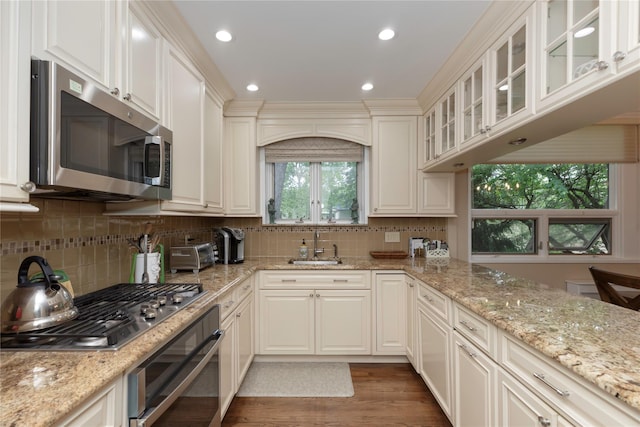 18 Channing Pl Unit 2R, Eastchester, NY 10709 - kitchen featuring stainless steel appliances, wood finished floors, decorative backsplash, glass insert cabinets, and light stone countertops