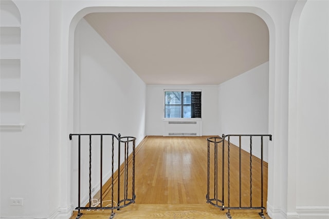 2506 Davidson Ave Unit 3C, Bronx, NY 10468 - hallway featuring radiator, arched walkways, an upstairs landing, and wood finished floors
