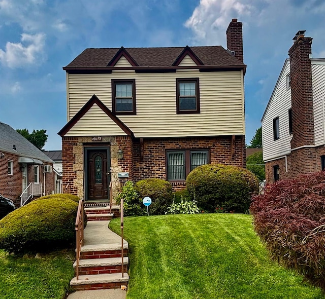163-49 16th Ave, Whitestone, NY 11357 - view of front of house featuring a front lawn, a chimney, and brick siding