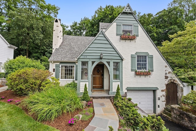 100 Norman Rd, New Rochelle, NY 10804 - view of front of property featuring a chimney, an attached garage, a shingled roof, and stucco siding