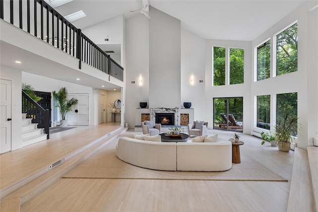 12 Zeck Ct, Suffern, NY 10901 - sunken living room with high vaulted ceiling, a fireplace, wood finished floors, and stairs