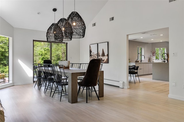 12 Zeck Ct, Suffern, NY 10901 - dining room featuring a chandelier, a baseboard radiator, light wood-style floors, and high vaulted ceiling