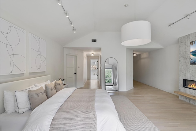 12 Zeck Ct, Suffern, NY 10901 - bedroom with track lighting, light wood-style floors, a high end fireplace, and high vaulted ceiling