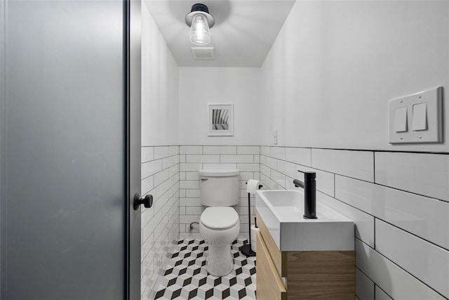 12 Zeck Ct, Suffern, NY 10901 - half bathroom with vanity, wainscoting, tile walls, and tile patterned flooring