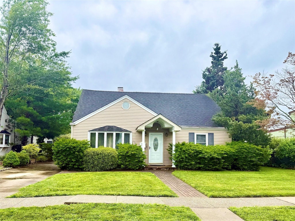 8 Violet Ave, Hicksville, NY 11801 - view of front of house with a shingled roof, a front yard, and a chimney