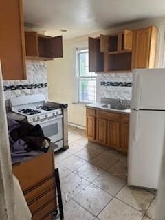 111 S Fulton Ave, Mount Vernon, NY 10550 - kitchen with white appliances, tasteful backsplash, light tile patterned flooring, and brown cabinets
