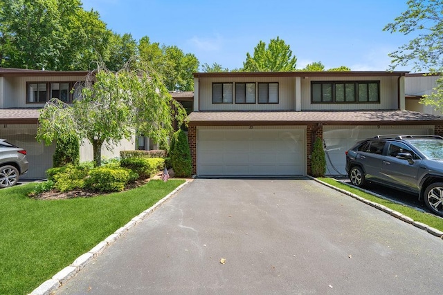 10 Pond View Ct Unit 10, Jericho, NY 11753 - view of front of home with a garage, driveway, brick siding, and a front yard