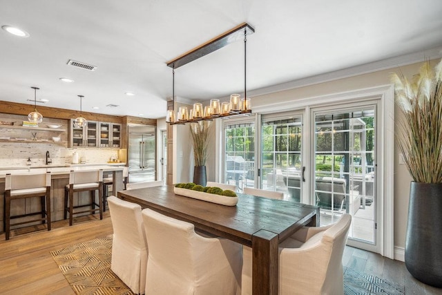 10 Pond View Ct Unit 10, Jericho, NY 11753 - dining room featuring light wood-style floors, recessed lighting, crown molding, and a chandelier