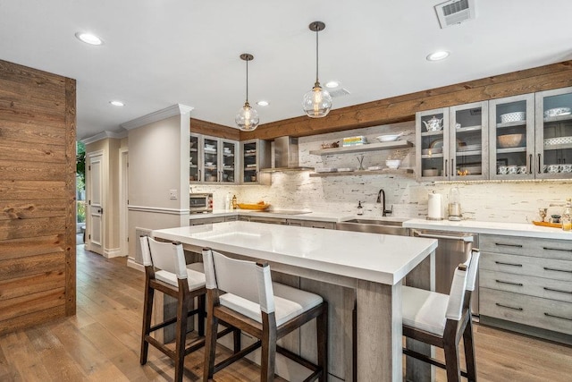 10 Pond View Ct Unit 10, Jericho, NY 11753 - kitchen featuring wall chimney range hood, recessed lighting, decorative backsplash, light countertops, and a kitchen breakfast bar
