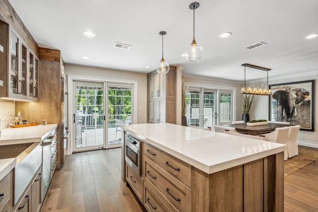10 Pond View Ct Unit 10, Jericho, NY 11753 - kitchen with glass insert cabinets, a kitchen island, wood finished floors, light countertops, and recessed lighting