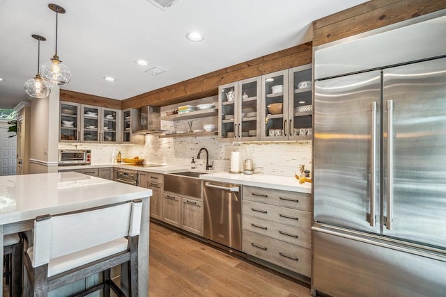10 Pond View Ct Unit 10, Jericho, NY 11753 - kitchen featuring appliances with stainless steel finishes, decorative backsplash, light countertops, glass insert cabinets, and recessed lighting