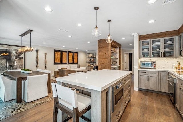 10 Pond View Ct Unit 10, Jericho, NY 11753 - kitchen with wall oven, stainless steel microwave, wood finished floors, recessed lighting, and ornamental molding