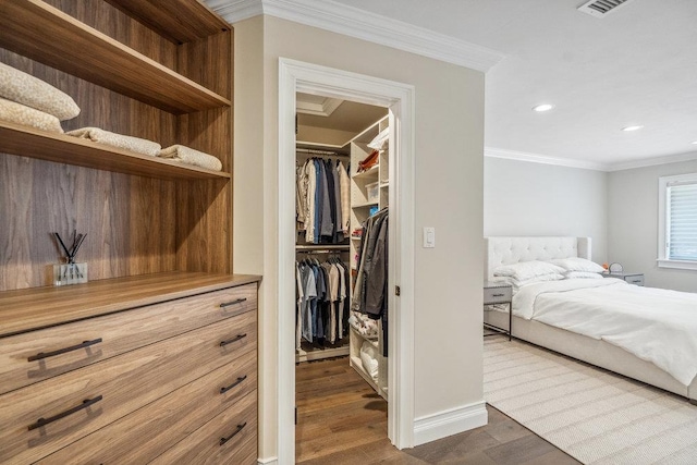 10 Pond View Ct Unit 10, Jericho, NY 11753 - bedroom featuring a spacious closet, dark wood-type flooring, a closet, ornamental molding, and recessed lighting