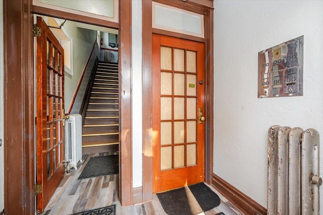 2312 Morgan Ave, Bronx, NY 10469 - foyer featuring radiator heating unit, wood finished floors, stairs, and a textured wall