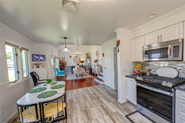 105 Graywood Ct, West Islip, NY 11795 - kitchen featuring stainless steel appliances, dark countertops, light wood-type flooring, tasteful backsplash, and white cabinetry