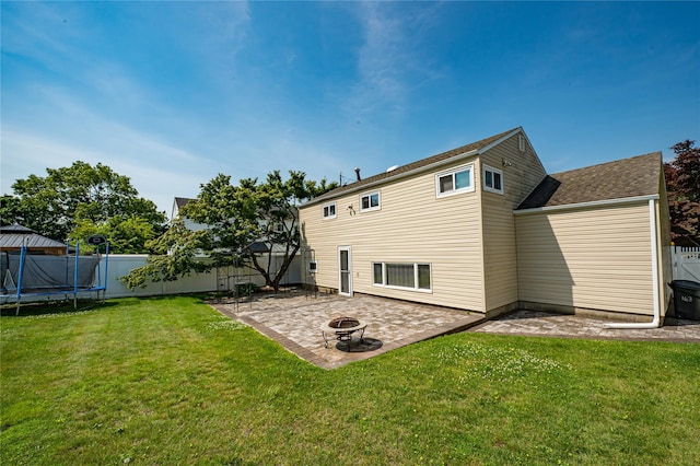 163 W 24th St, Deer Park, NY 11729 - rear view of house with a trampoline, a patio, a fire pit, and roof with shingles