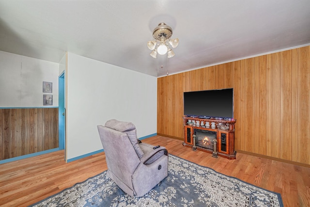 35 13th St, Bohemia, NY 11716 - living room featuring wood walls, light wood finished floors, and a warm lit fireplace