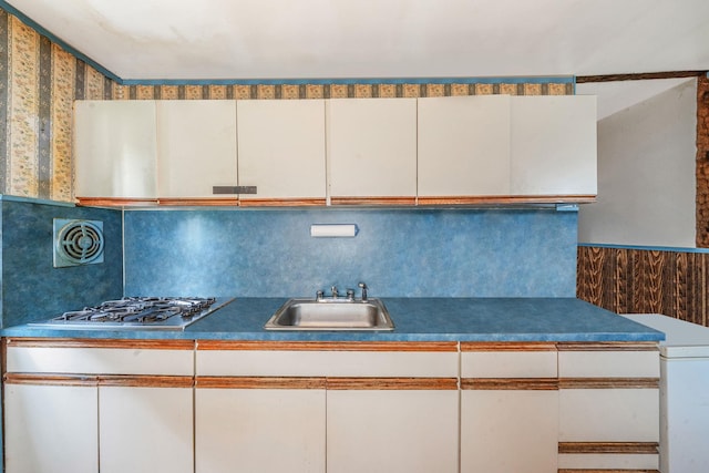 35 13th St, Bohemia, NY 11716 - kitchen featuring stainless steel gas stovetop, white cabinetry, dark countertops, and tasteful backsplash