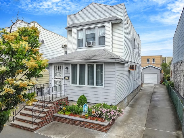 66-13 73rd Pl, Middle Village, NY 11379 - view of front of home featuring driveway, an outdoor structure, a garage, a shingled roof, and cooling unit