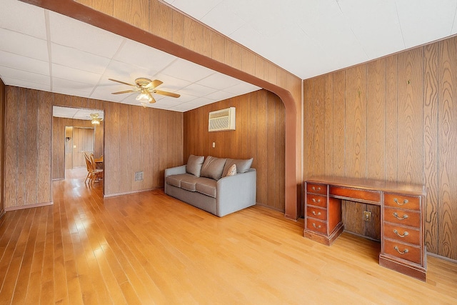 66-13 73rd Pl, Middle Village, NY 11379 - living room with light wood-type flooring, a ceiling fan, wooden walls, and a wall mounted AC