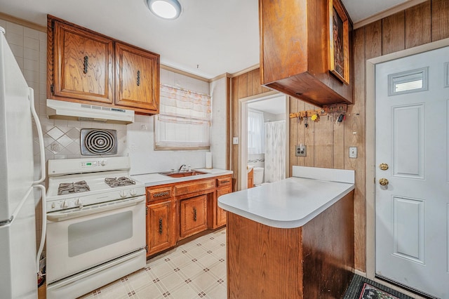 66-13 73rd Pl, Middle Village, NY 11379 - kitchen featuring white appliances, under cabinet range hood, light floors, brown cabinetry, and wood walls