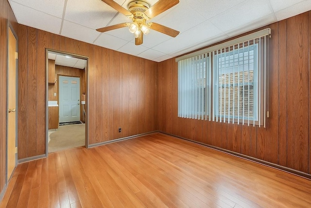 66-13 73rd Pl, Middle Village, NY 11379 - spare room with light wood-style flooring, wooden walls, and ceiling fan