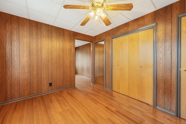 66-13 73rd Pl, Middle Village, NY 11379 - unfurnished bedroom featuring wood finished floors, wood walls, ceiling fan, and a closet