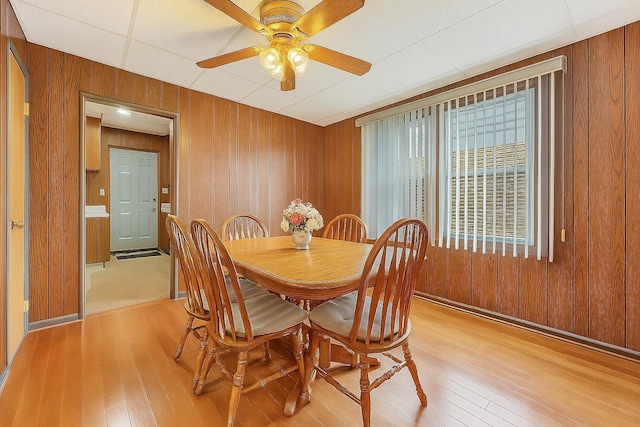66-13 73rd Pl, Middle Village, NY 11379 - dining room featuring wooden walls, light wood-style flooring, and a ceiling fan