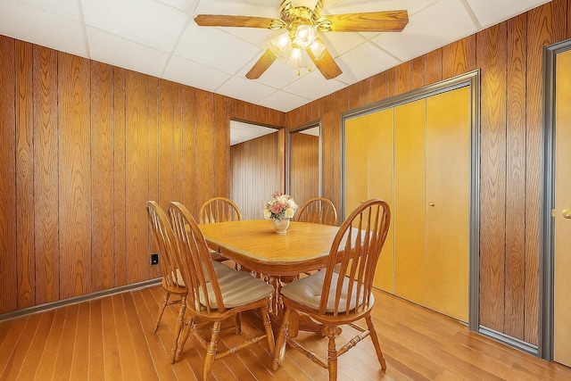 66-13 73rd Pl, Middle Village, NY 11379 - dining area with light wood-type flooring, ceiling fan, and wood walls