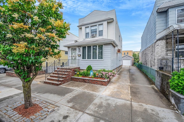66-13 73rd Pl, Middle Village, NY 11379 - view of front facade with a detached garage, an outbuilding, concrete driveway, and cooling unit