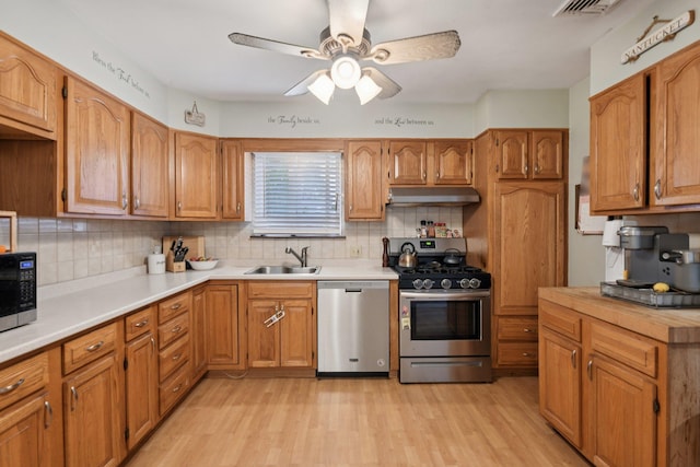 13 Sunset Dr, Centereach, NY 11720 - kitchen featuring stainless steel appliances, under cabinet range hood, light wood-type flooring, and ceiling fan