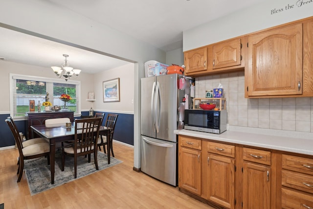 13 Sunset Dr, Centereach, NY 11720 - kitchen with appliances with stainless steel finishes, light wood-style floors, a chandelier, light countertops, and tasteful backsplash