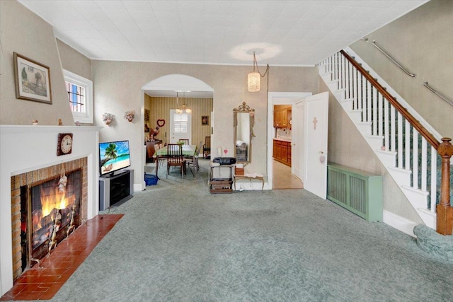 49 Boone St, Yonkers, NY 10704 - living area with carpet flooring, stairs, arched walkways, and a brick fireplace