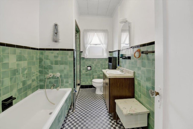 49 Boone St, Yonkers, NY 10704 - bathroom featuring tile walls, tiled tub, vanity, wainscoting, and tile patterned floors
