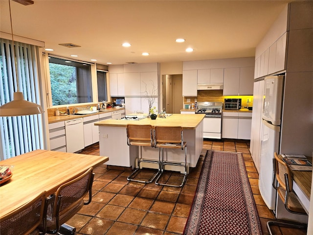 5 Sophia St, Monsey, NY 10952 - kitchen with white appliances, a kitchen island, white cabinetry, light countertops, and decorative backsplash