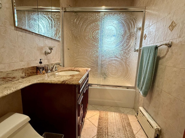 59-47 69th Ln Unit A, Maspeth, NY 11378 - full bath featuring radiator heating unit, vanity, tile patterned flooring, tile walls, and shower / bath combination with glass door