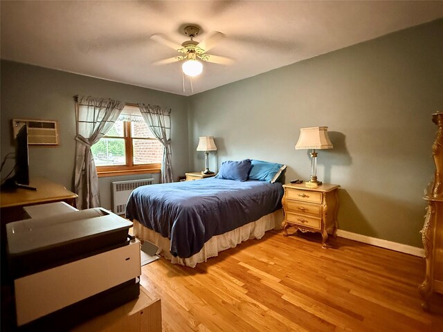 59-47 69th Ln Unit A, Maspeth, NY 11378 - bedroom featuring radiator heating unit, light wood-style flooring, a ceiling fan, and an AC wall unit